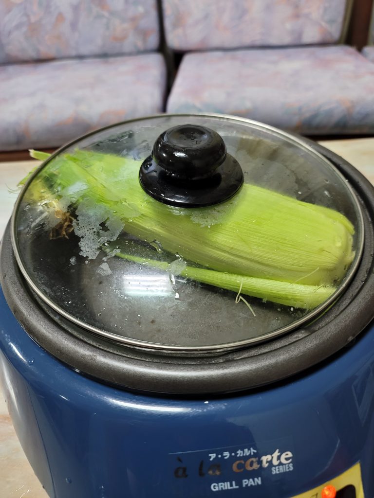 青森産ブランドトウモロコシ「嶽きみ」をホットプレートで蒸し焼きにしている様子