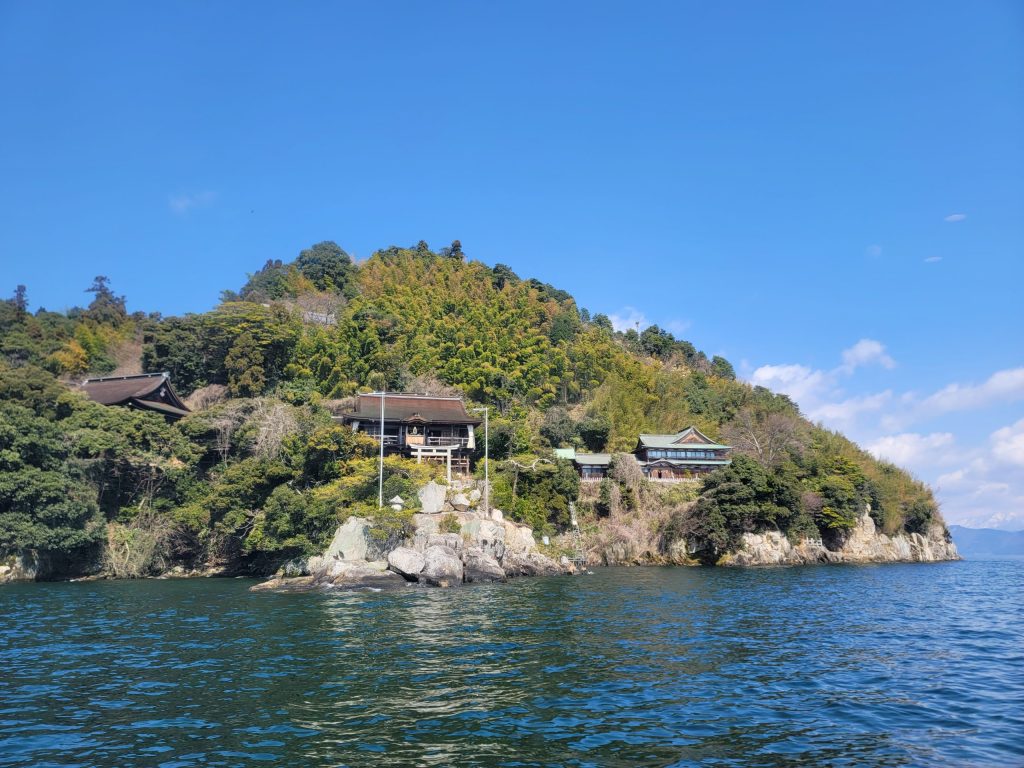 琵琶湖のフェリーから見た竹生島の全景。緑の山々と湖面が美しく広がる風景。