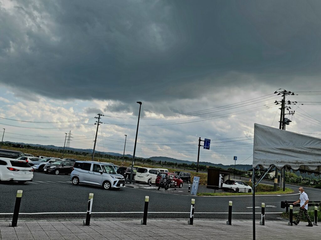 道の駅平泉の駐車場越しに広がるどす黒い雨雲