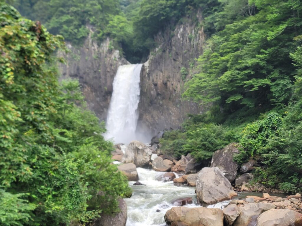 目の前で豪快に流れ落ちる苗名滝の様子。轟音と水しぶきが迫力満点で、自然のエネルギーを全身で感じられる風景。