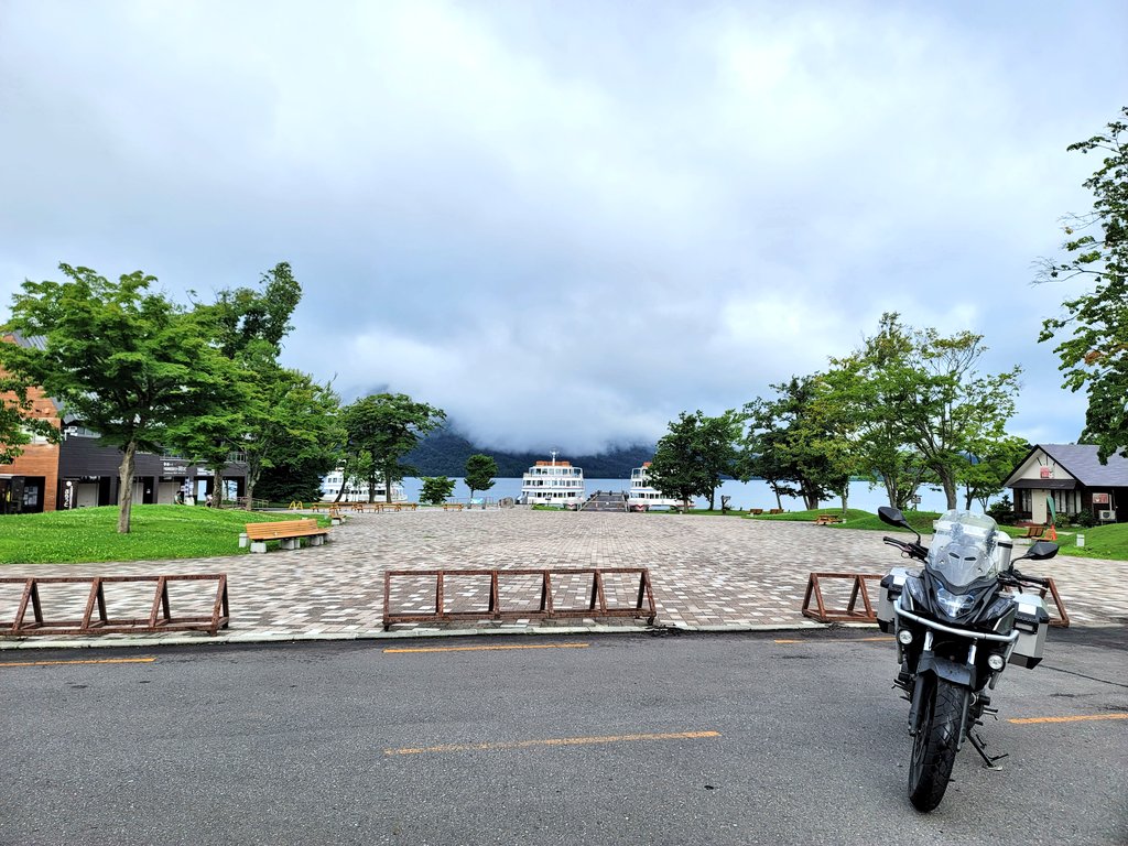 十和田湖畔のフェリー乗り場に停めたバイクの記念写真。湖と愛車を背景にした東北ツーリングの思い出。