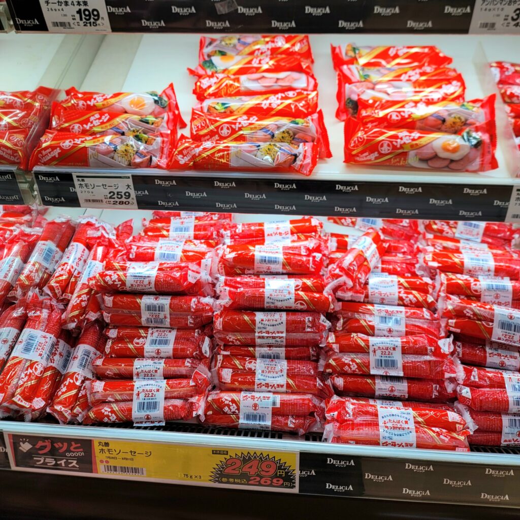 白馬のスーパーで、長野県民に愛されるホモソーセージが並ぶ商品棚の写真。