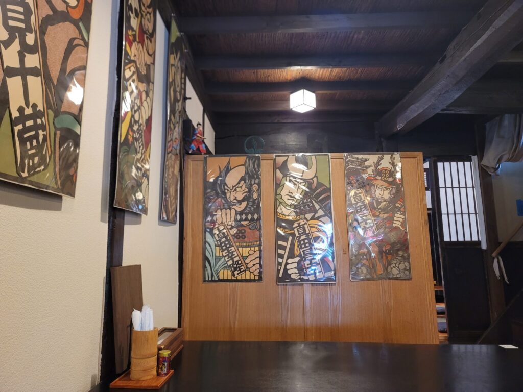 長野県上田市「手打ちそば 元祖真田流手打ちそば佐助」真田一族の絵が飾られたそば屋の店内。古民家の落ち着いた空間に真田家ゆかりの雰囲気が漂う。