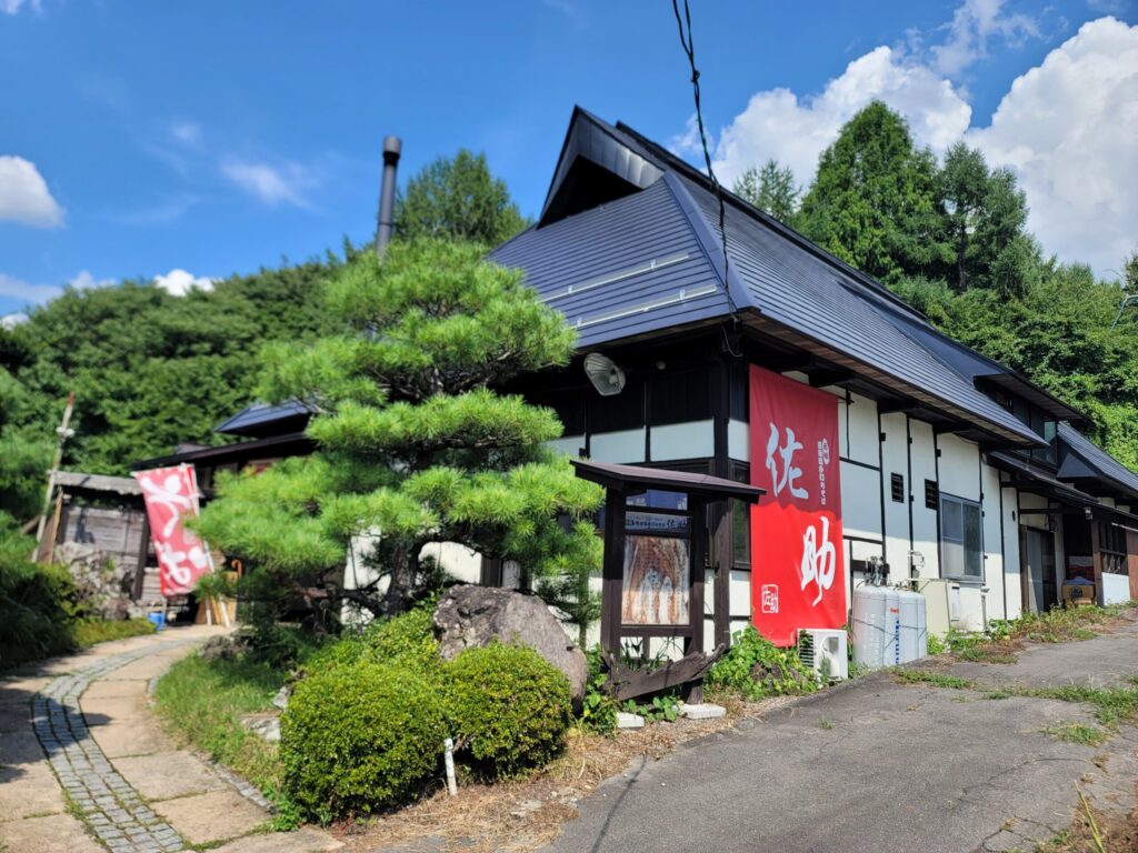 長野県上田市「手打ちそば 元祖真田流手打ちそば佐助」江戸時代に建てられた飯山市の古民家を移築したそば屋の外観。歴史を感じさせる木造建築。