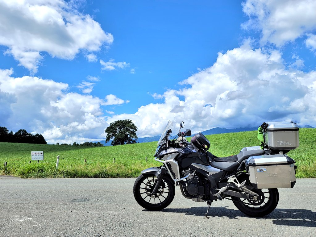 入道雲が広がる青空の下、小岩井農場の一本桜とバイクが並ぶ風景
