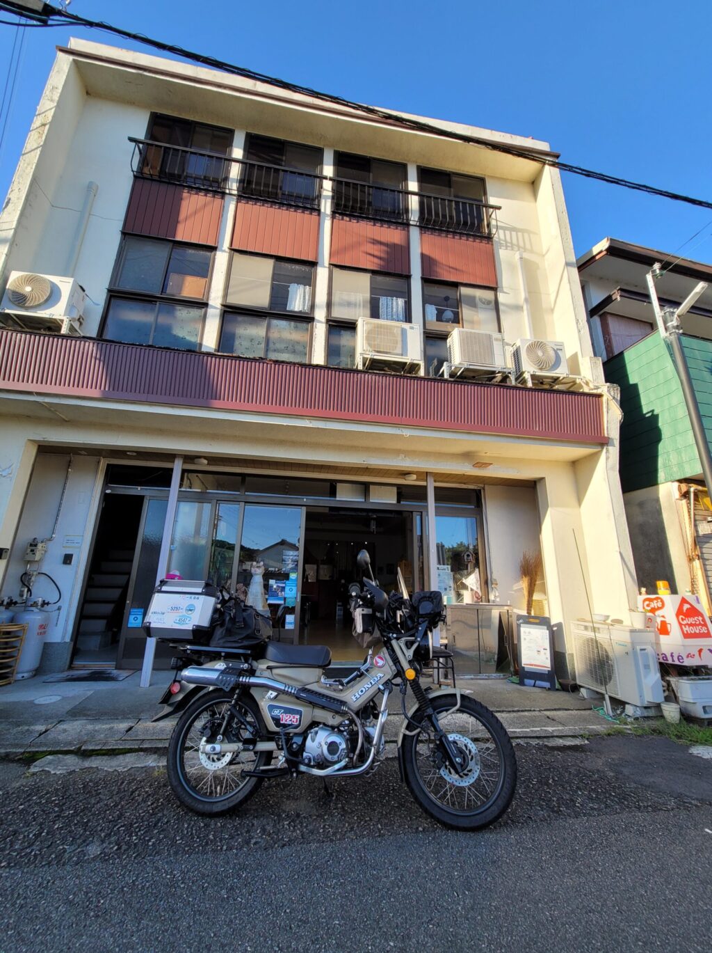 昭和風レトロ建物とゲストハウスカフェ 口熊野前に停められたハンターカブ