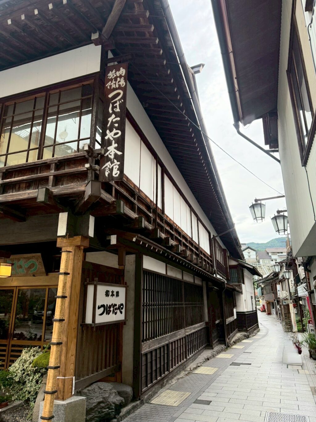 長野、渋温泉街の石畳に面して建つ、つばたや旅館の外観を斜め方向から撮影した様子