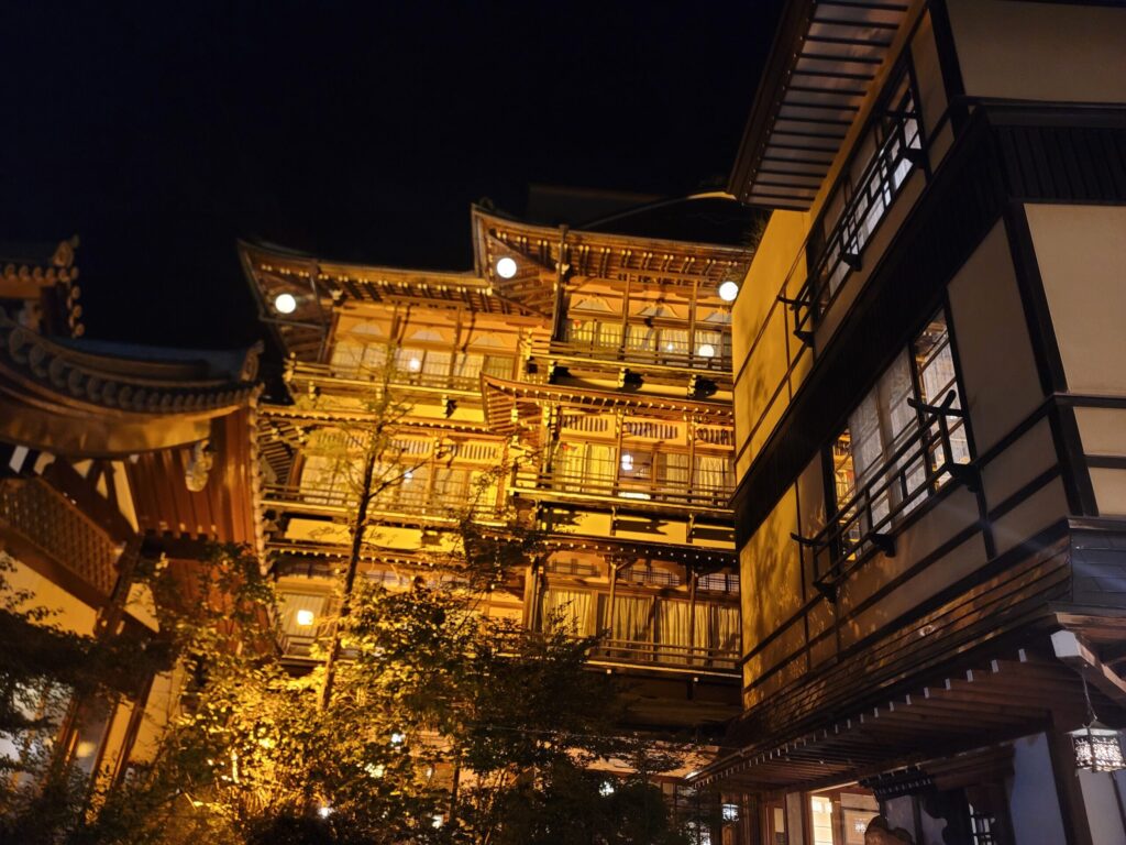 夜にライトアップされた渋温泉の金具屋旅館の外観。千と千尋の神隠しのモデルとしても知られる歴史ある木造建築