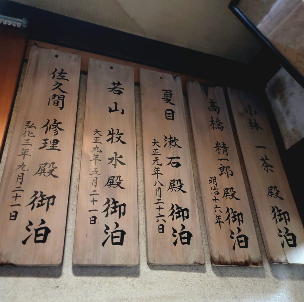 つばたや旅館に飾られている名札。夏目漱石や若山牧水、小林一茶など歴史的著名人が宿泊した記録が残る