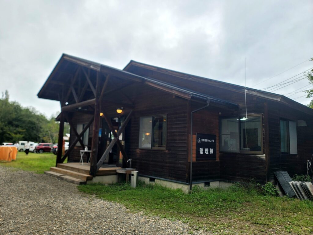 長野・立原高原キャンプ場の管理棟と砂利道。バイクでの出入りは注意が必要