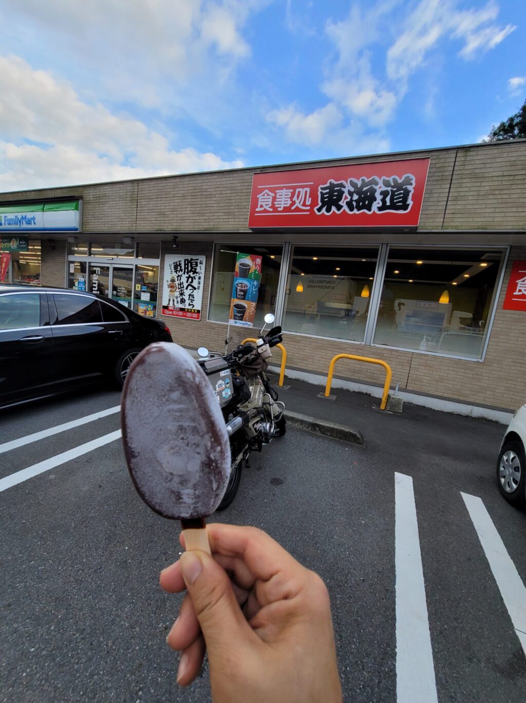 静岡市の食事処東海道の看板が見える場所でアイス(パルム)を食べている写真。