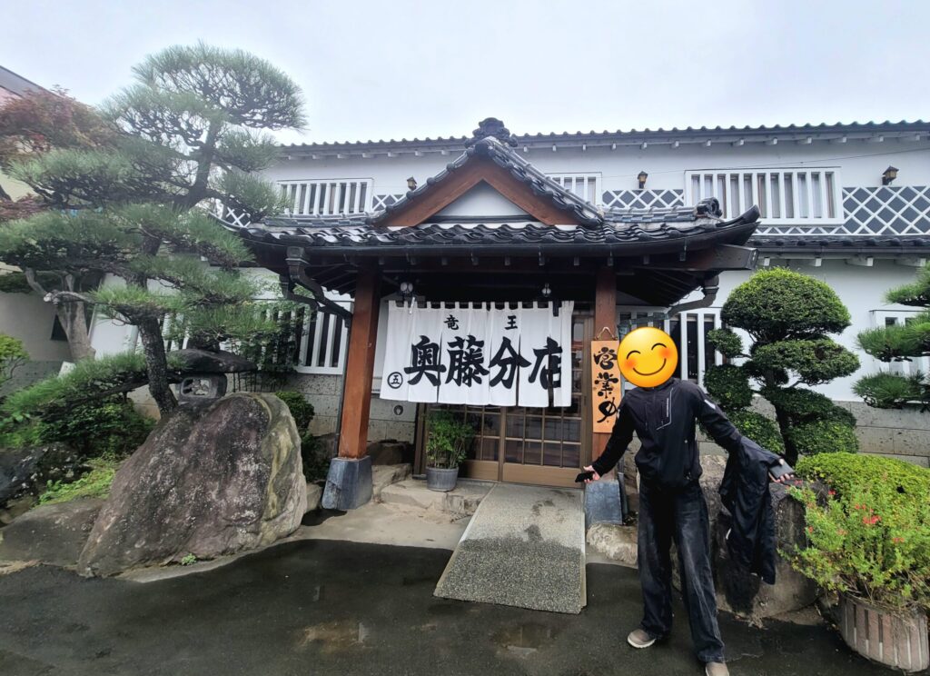 ゆるキャン△でもおなじみの山梨ご当地そば店「竜王 奥藤分店」の前で、ツーリング途中に記念撮影をする息子の様子