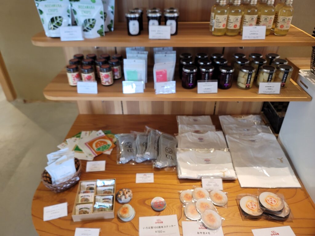 長野、川中島のおやきファーム店内の雑貨売り場の様子。おやきステッカーやメモ帳、地元食材を使ったドレッシングなどが並び、旅のおみやげ選びを楽しめるコーナー。