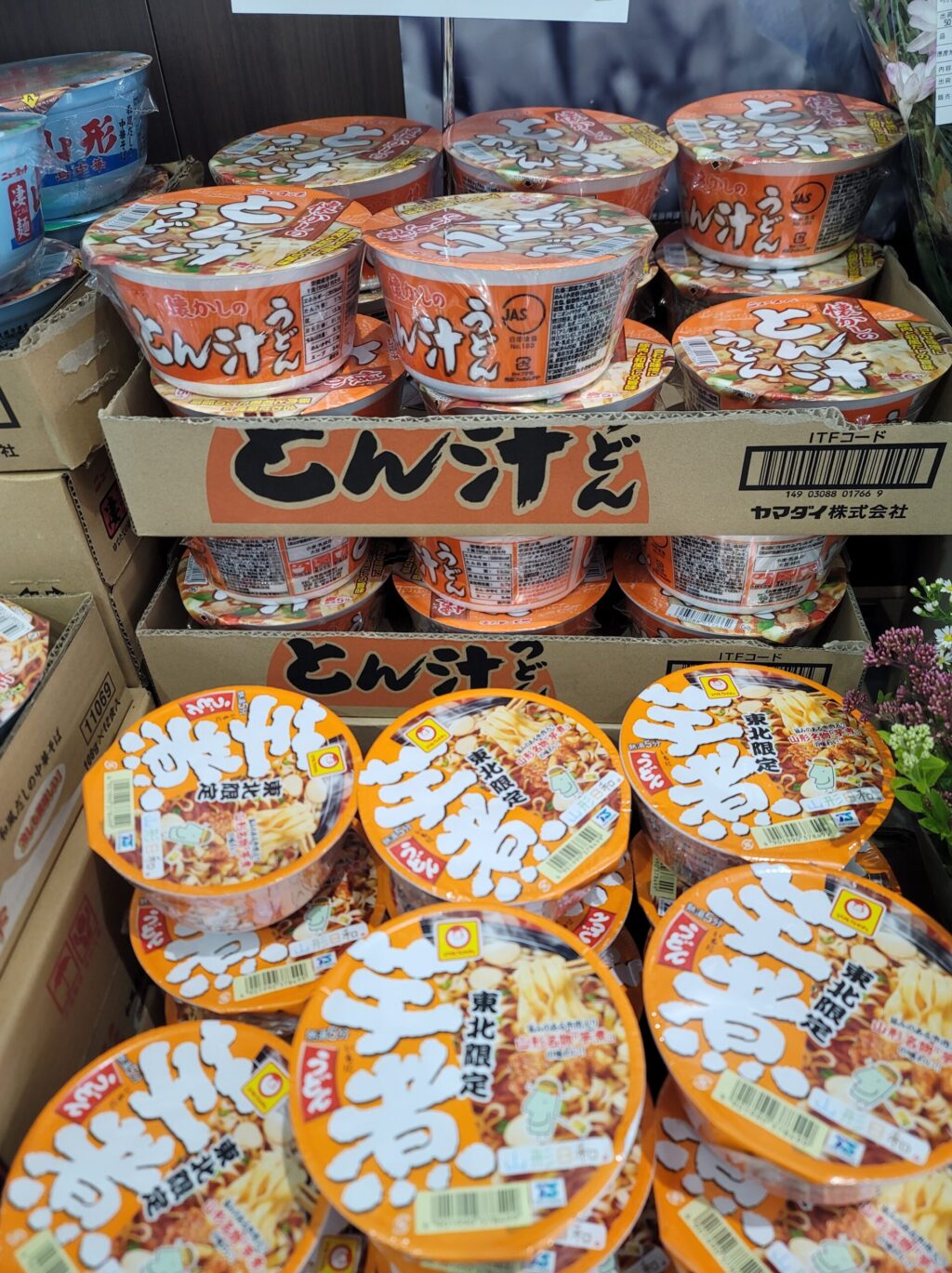 山形、豚汁うどんのカップラーメンが並ぶ売店の棚|ご当地インスタント麺が豊富な道の駅かわのみなと長井