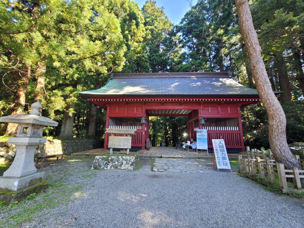 羽黒山の隋神門を正面から撮影した写真。参道の杉並木に囲まれた厳かな佇まい