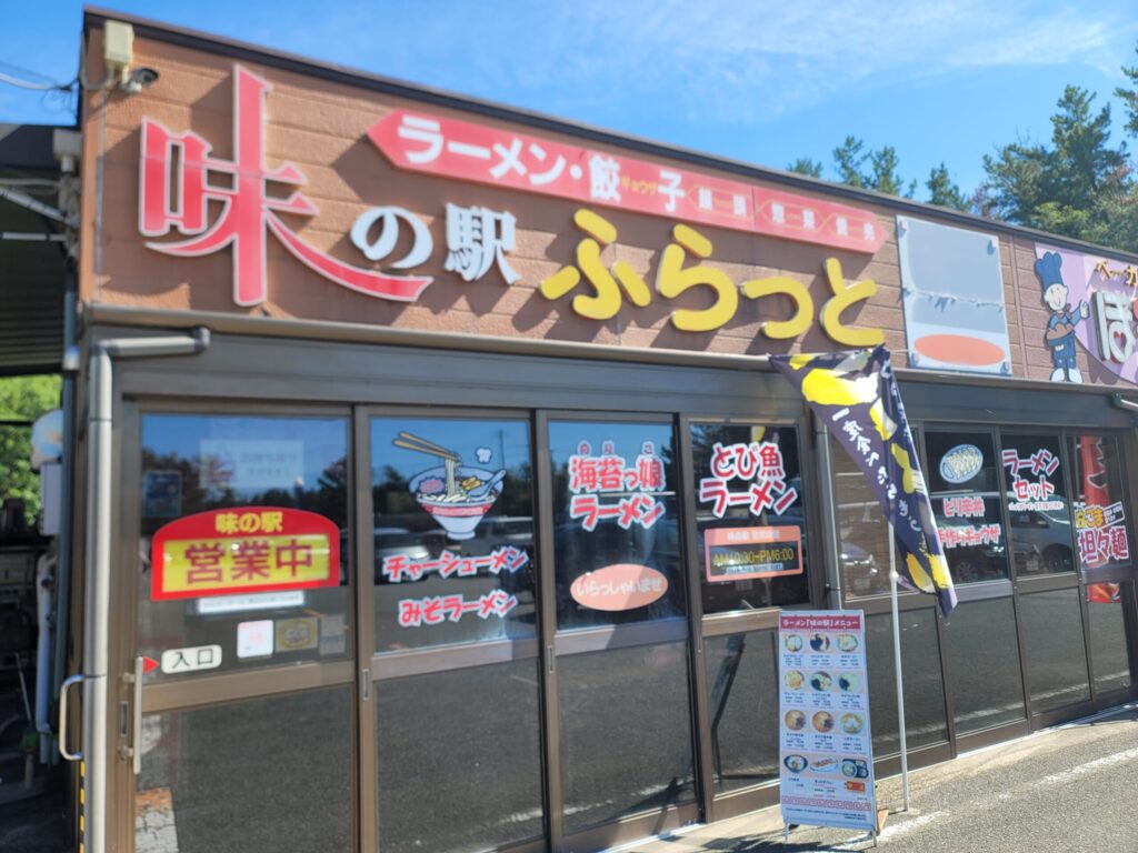 道の駅鳥海ふらっとのラーメン屋外観。海苔や飛びうおのステッカーが貼られた店先の写真