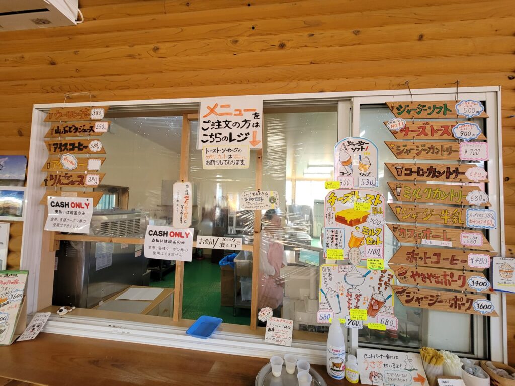 仁賀保高原の土田牧場売店の写真。ジャージー牛乳やソフトクリーム、ウインナーなどが並ぶ