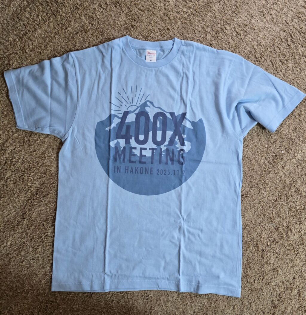 00X MEETING in HAKONE 2025.11.2 の記念Tシャツ。水色のボディに山のロゴ
