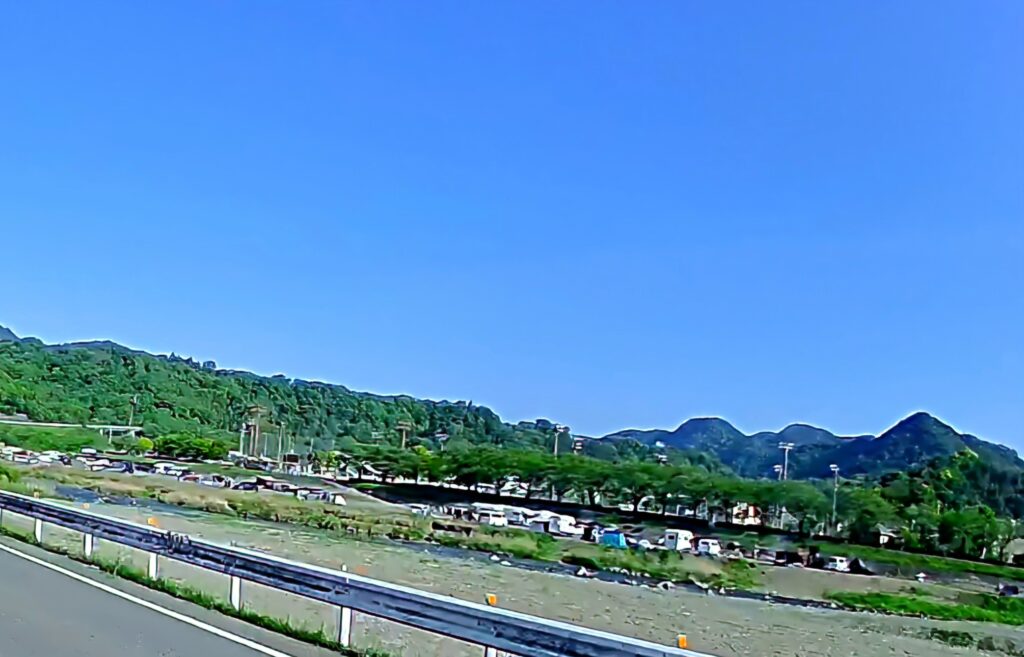 神奈川県愛川町田代運動公園の河原にたくさんのテントや車が並んでいる様子