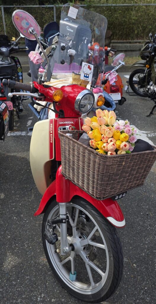 キティちゃんとコラボの赤いスーパーカブ。かごにお花が飾ってある。
