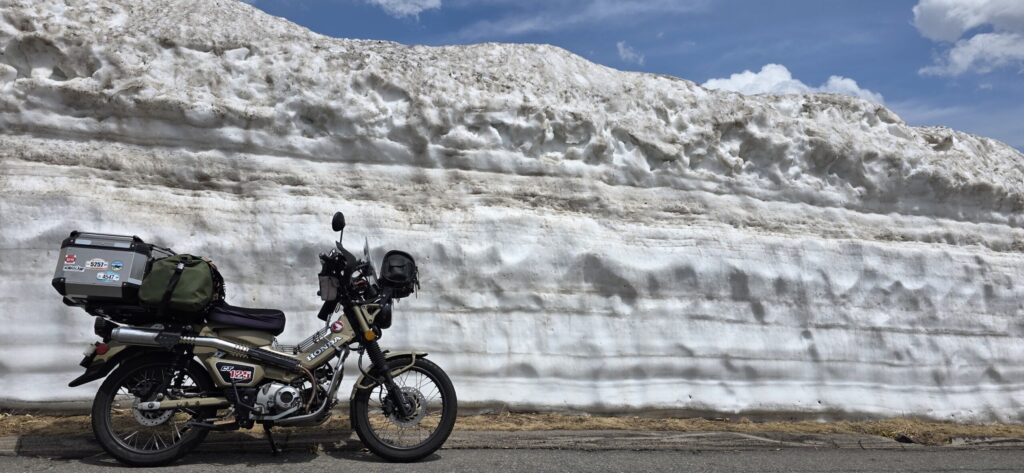 渋峠の雪の回廊の雪の壁とハンターカブが写る景色