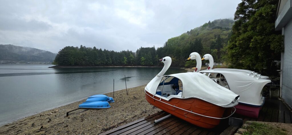雨の青木湖キャンプ場の湖岸に並ぶアヒルのボート