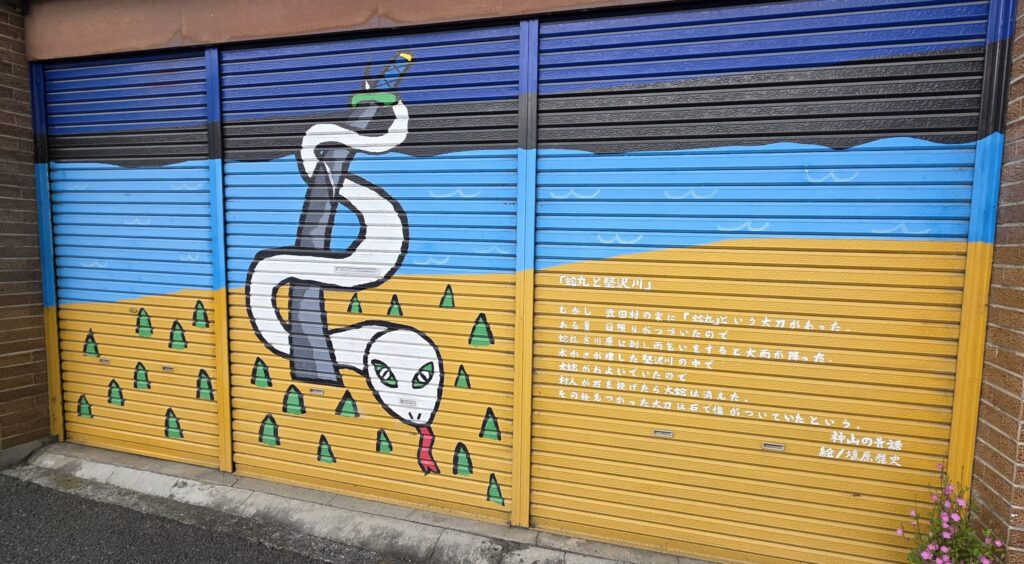山梨県韮崎駅周辺の店舗のシャッターに描かれた絵。山梨の昔話の絵が描かれている