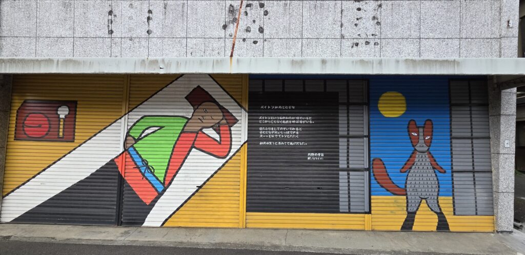 山梨県韮崎駅周辺の店舗のシャッターに描かれた絵。山梨の昔話の絵が描かれている
