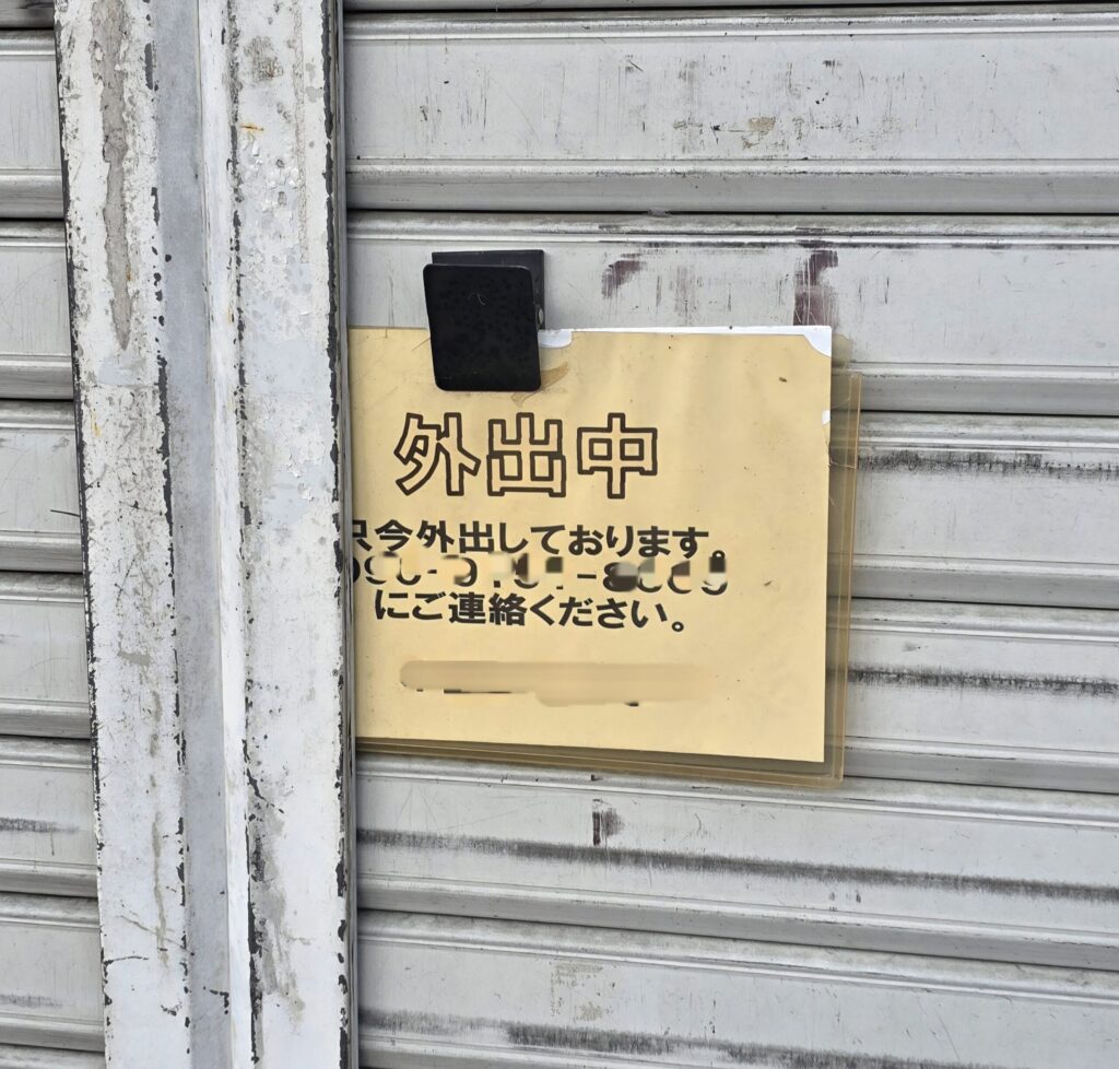 山梨県韮崎市のバイク店のシャッターに貼られた不在案内の張り紙
