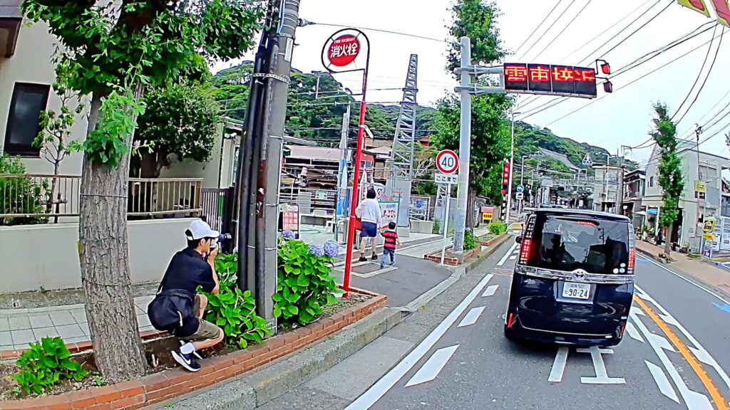 鎌倉で江ノ電を撮影する人と線路沿いの風景