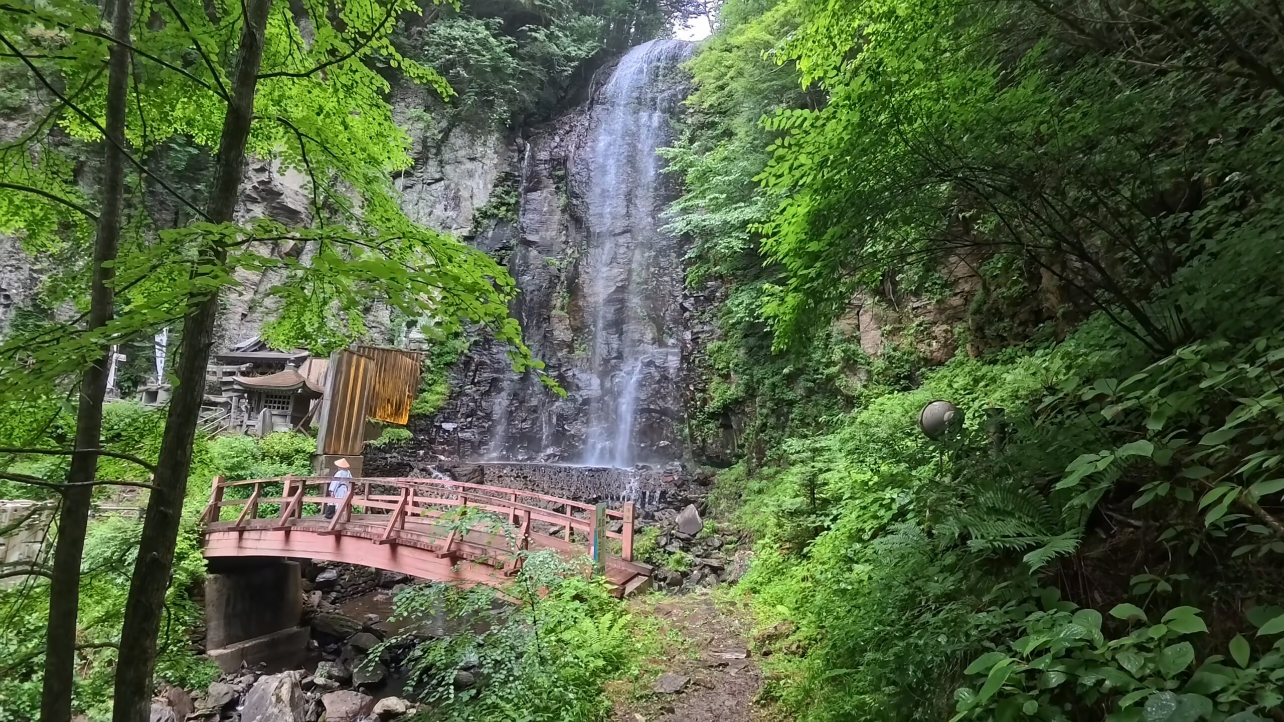 長野・木曽・清滝の全景。赤い橋と滝の流れる様子
