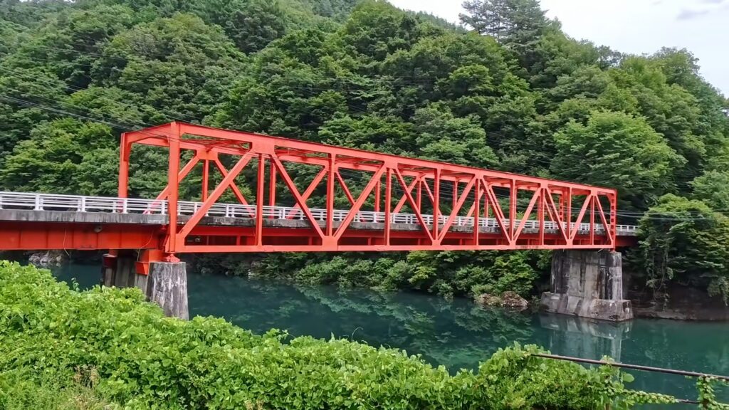 道の駅三岳そばの黒田橋。赤い橋と王滝川の緑の対比が美しい