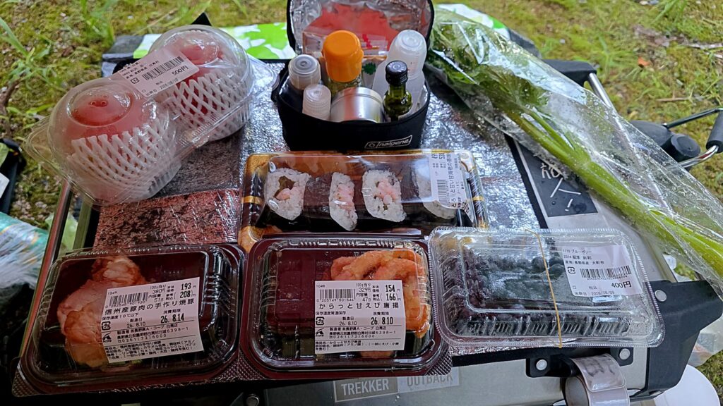 青木湖キャンプ場での夕食の様子。テーブルにはフルーツやお惣菜が並んでいる。