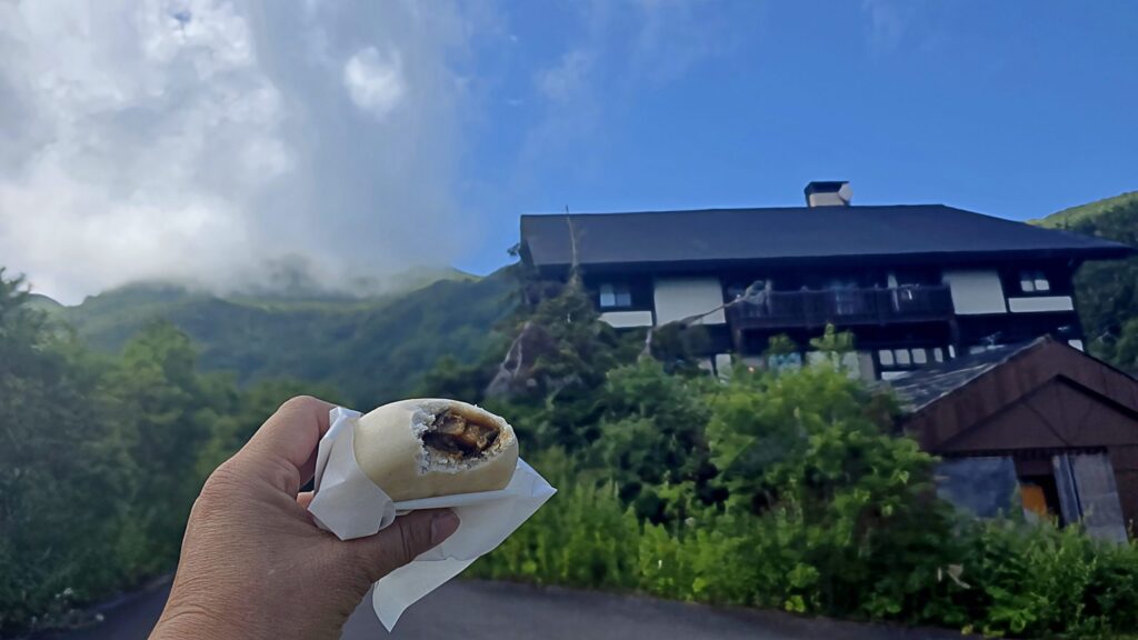 栂池ヒュッテで購入したおやきを食べている様子