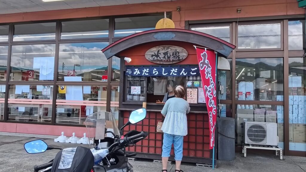 飛騨、駿河屋のみたらし団子の出店でお客さんがみたらし団子を買う様子